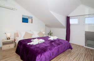 ein Schlafzimmer mit einem lila Bett mit zwei Kissen in der Unterkunft Apartment Superb View 2 in Dubrovnik