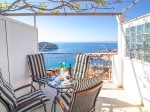 ein Balkon mit Tisch und Stühlen und dem Meer in der Unterkunft Apartment Superb View 2 in Dubrovnik