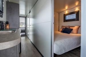 a small bedroom with a bed and a sink at Waterlodge voor 4 personen in de haven van Kamperland in Kamperland
