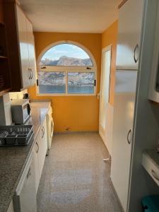 eine Küche mit einer orangefarbenen Wand und einem Fenster in der Unterkunft Hornillo Vistas al Mar in Águilas