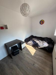 a bedroom with a bed and a table and a chandelier at Apartament na spokojnej wsi in Trzebiel