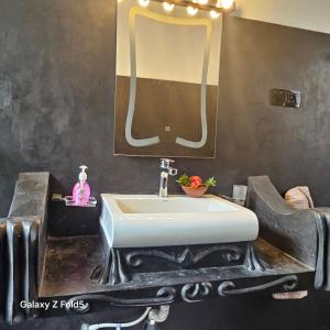 a bathroom with a white sink and a mirror at Angelica Villa in Bentota