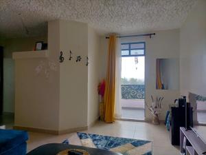 a living room with a door open to a patio at Blue Petals Homestays in Nanyuki +5 photos