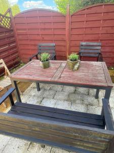 a wooden table with two plants on a patio at Apartament na spokojnej wsi in Trzebiel