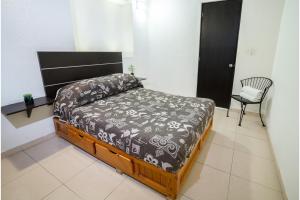 un dormitorio con una cama y una silla en Casona Poblana Hotel Puebla, en Puebla