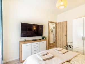 a bedroom with a bed and a flat screen tv at Berliner Apartman by Mital in Szeged