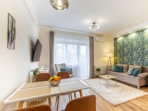 a living room with a table and a couch at Berliner Apartman by Mital in Szeged