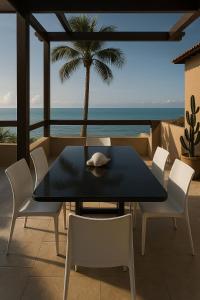 a table and chairs on a balcony with the ocean at La France in Caucaia