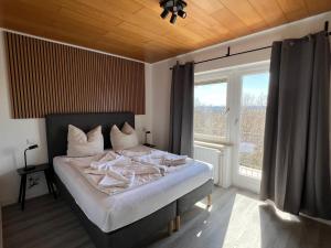 a bedroom with a bed and a large window at Hotel Bastei in Mühldorf