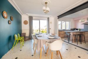 a dining room and kitchen with a table and chairs at La Maison de Marion - 15min à pied de la plage in Outreau
