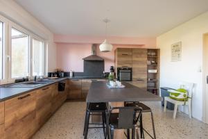 a kitchen with wooden cabinets and a table with chairs at La Maison de Marion - 15min à pied de la plage in Outreau +7 photos
