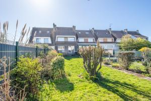 a garden in front of a row of houses at La Maison de Marion - 15min à pied de la plage in Outreau