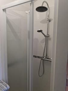 a shower with a glass door in a bathroom at chambre du Saussay in Villers-Écalles
