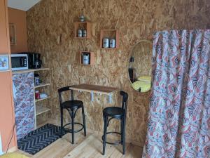 a small kitchen with a table and two stools at chambre du Saussay in Villers-Écalles