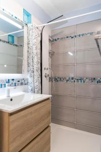 ein Badezimmer mit Waschbecken und Dusche in der Unterkunft Le Nautilus in Gruissan