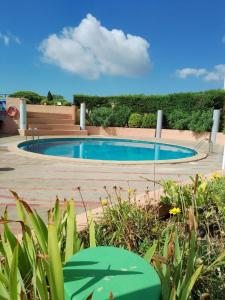 ein Pool in einem Garten mit Pflanzen in der Unterkunft Le Nautilus in Gruissan