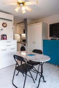 eine Küche mit Tisch und Stühlen in einem Zimmer in der Unterkunft Le Nautilus in Gruissan + 2 Fotos