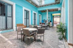 a patio with tables and chairs on a blue wall at Casona Poblana Hotel Puebla in Puebla