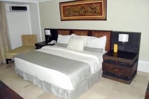 una camera da letto con un grande letto bianco e una sedia di Jades Hotel ad Abuja