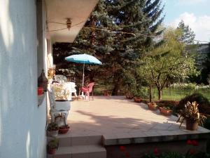 un patio con mesa y sombrilla en Budakeszi magánszállás, en Budakeszi