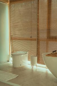 a bathroom with a tub and a toilet and a sink at Yanai at Anai - Private Pool & Private Cook in Varagampadi +34 photos