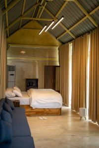 a bedroom with a bed and a couch in a room at Yanai at Anai - Private Pool & Private Cook in Varagampadi