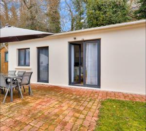 ラ・ボールにあるJolie Maisonnette avec terrasseのテーブルと椅子のあるパティオのある家