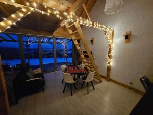 ein Wohnzimmer mit einem Tisch mit Stühlen und Lampen in der Unterkunft Widokowe Stodoły Bieszczady - domy z panoramą połonin in Lesko