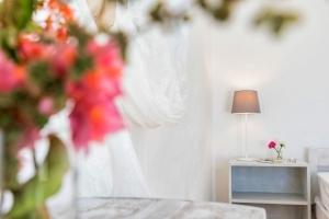 a room with a bed and a table with flowers at Sun Drop 1 with private pool, 5-min walk to Drios beach in Drios