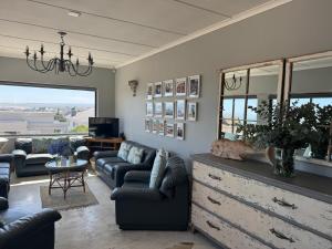 a living room with couches and a dresser with a couch and a tv at Uitsig in Yzerfontein