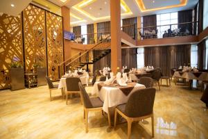 a restaurant with white tables and chairs and a staircase at Vamos Addis Hotel in Addis Ababa