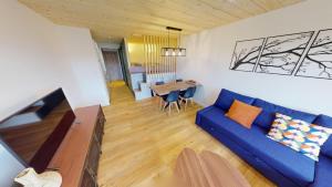 a living room with a blue couch and a table at Charme du Mont d'Or in Métabief