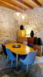 a dining room with a wooden table and blue chairs at Charmante maison de ville en pierre avec piscine in Eysines +26 photos