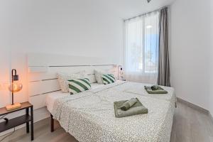 a white bedroom with a bed and a window at Luz de la Luna - Ocean View - Las Americas in Costa de Adeje +7 photos