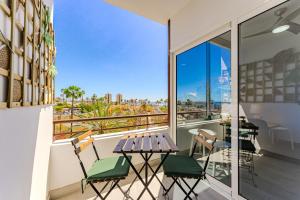 a balcony with a table and chairs and a view of the city at Luz de la Luna - Ocean View - Las Americas in Costa de Adeje
