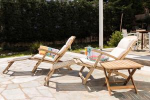 two wooden chairs and a wooden table and a chair at Sun Drop 2 with mini pool, 5-min walk to Drios beach in Drios +54 photos