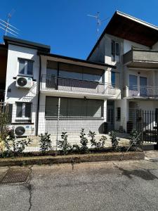 a white house with a fence in front of it at Little House Leonardo Airport in Azzano San Paolo +26 photos