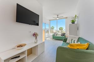 a living room with a green couch and a flat screen tv at Luz de la Luna - Ocean View - Las Americas in Costa de Adeje