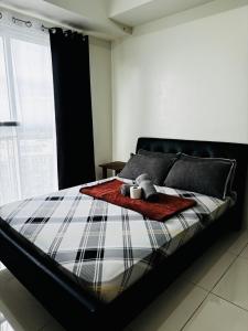a bed with a blanket and two candles on it at Wind Suites Tagaytay Condotel in Tagaytay +20 photos
