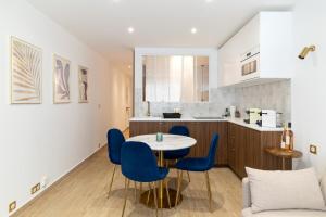 una cucina e una sala da pranzo con tavolo e sedie blu di Appartement de Charme à 5 minutes de la mer a Antibes