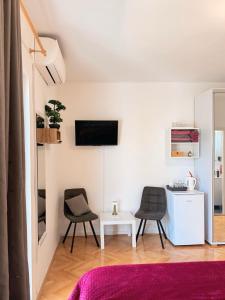 a living room with two chairs and a table at Rooms Kate in Krk