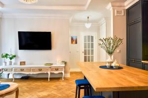 ein Wohnzimmer mit Tisch und Fernseher in der Unterkunft Le Petit Okopowa - apartament w centrum Lublina in Lublin