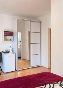 a large mirrored closet in a room with a red rug at Rooms Kate in Krk