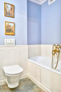 ein Badezimmer mit einer weißen Badewanne und einem WC in der Unterkunft Le Petit Okopowa - apartament w centrum Lublina in Lublin