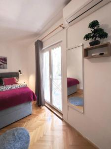 a bedroom with a mirror and a bed and a window at Rooms Kate in Krk