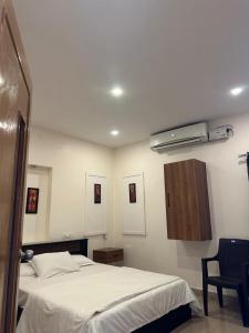 Un dormitorio con una cama blanca y aire acondicionado. en GardInn, en Visakhapatnam
