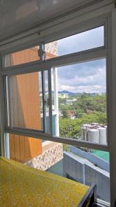 - une fenêtre dans une chambre avec vue sur un bâtiment dans l'établissement Grand View Unit 504 Condo Transient by Dei Gratia, à Baguio