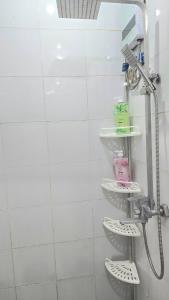 une douche dans une salle de bain avec du carrelage blanc dans l'établissement Grand View Unit 504 Condo Transient by Dei Gratia, à Baguio