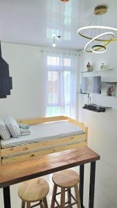 un lit dans une chambre avec deux tabourets dans l'établissement Grand View Unit 504 Condo Transient by Dei Gratia, à Baguio