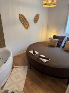 una camera da letto con un letto grande e una vasca da bagno di T2, Balneo, sauna, lit rond, jeux arcades, parking a Tournefeuille